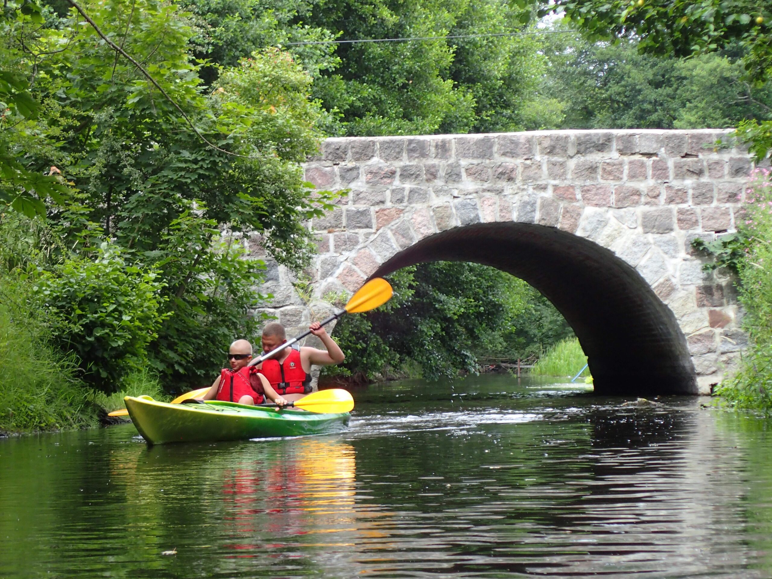tata z synem płyną kajakiem po Drawie