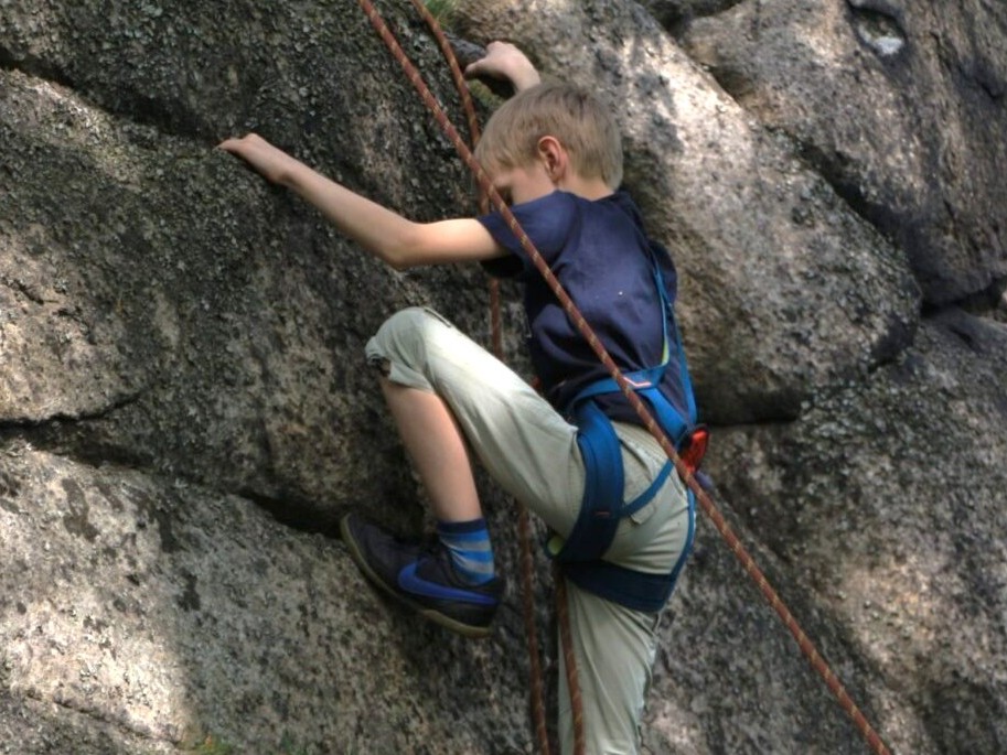 Dziecko wspina się na skałę